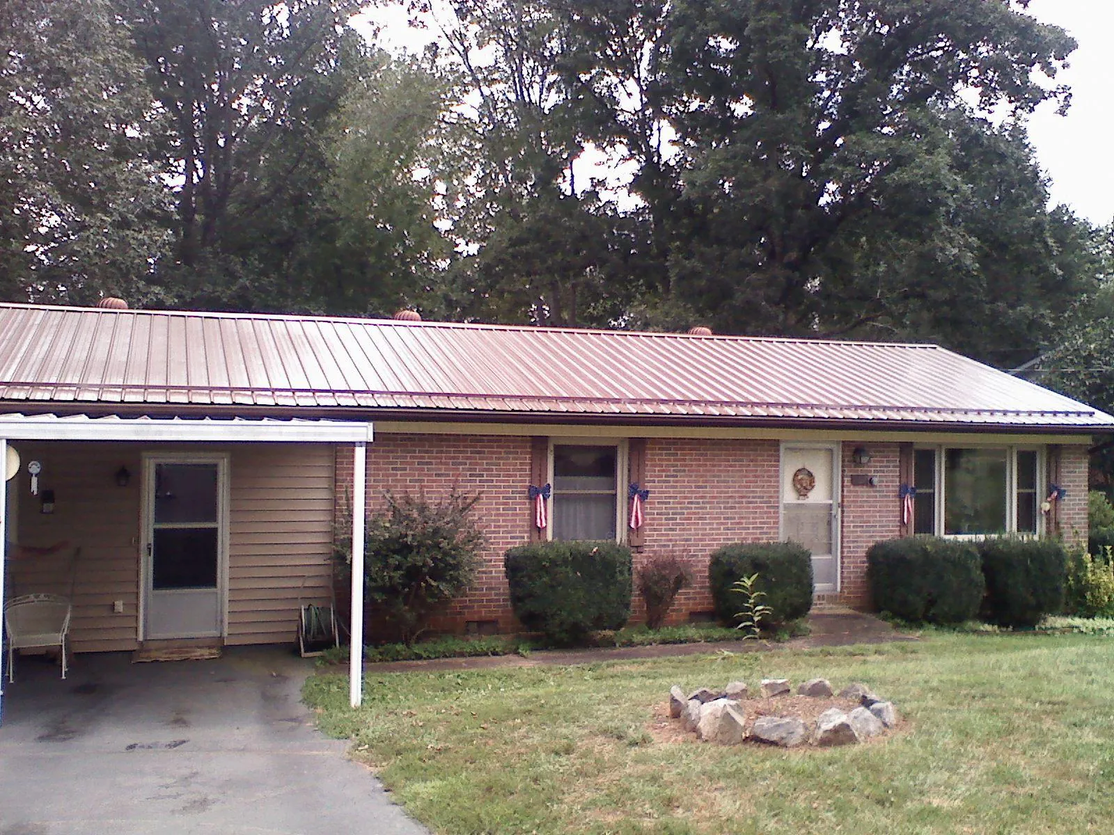 Bronze metal roof and carport on a brick ranch home — Roof Repair work by our crew in Alberton